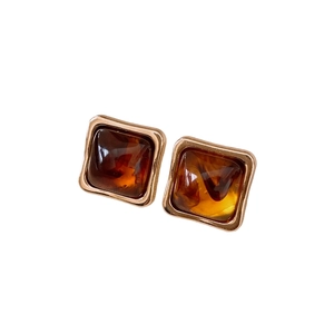 Vintage gold square earrings with amber-pattern resin in a professional studio shot