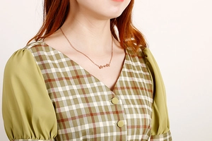 Close-up of rose gold butterfly pendant necklace on model's neck for elegant fashion look