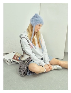 Close-up of fluffy blue ear-flap beanie paired with a casual Y2K streetwear outfit