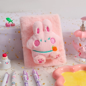 Close-up of pink plush bunny notebook with soft faux fur texture and embroidered details