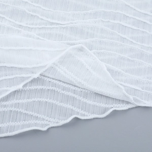 Makroaufnahme von weißem Spitzenstoff mit Wellenstruktur und semi-transparentem Mesh