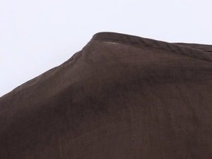 Gros plan détaillé montrant les coutures et la texture du col en coton marron foncé