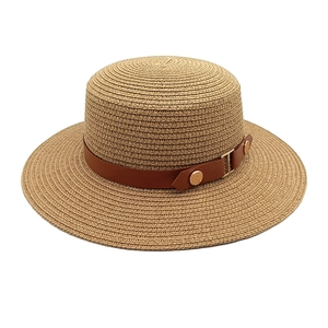 Flat top wide brim straw hat with brown leather band and gold buckle on white background