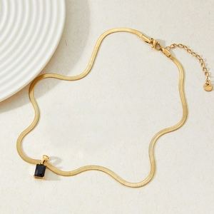 Collier élégant à chaîne serpent dorée avec pendentif carré en zircon noir sur papier