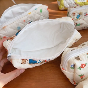 Close-up of quilted cotton storage bag showing cute animal prints and inner fabric lining