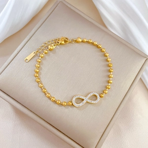 Macro shot of gold infinity symbol bracelet with crystals and S.Steel hallmark tag