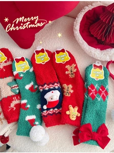 Détail de chaussettes de Noël en polaire corail avec motifs pain d'épice et Père Noël