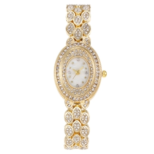 Macro shot of oval gold quartz watch with sparkling rhinestones and mother-of-pearl dial