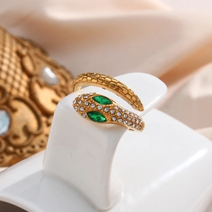 Macro shot of 18K gold snake ring with sparkling crystals and green gem eyes