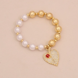 Detail of beaded bracelet with faux pearls and leaf charm featuring a red enamel ladybug