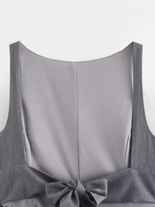 Détail du haut gris montrant le nœud papillon au dos et la coupe dos nu élégante
