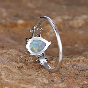 Vintage silver ring with pear-shaped fire opal and small white zircons on stone surface
