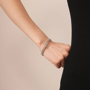 Detail of silver double row tennis bracelet with round rhinestones on woman wrist