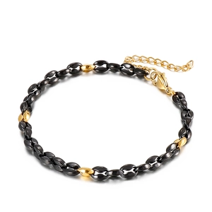 Dettaglio del bracciale bicolore nero e oro con chiusura a moschettone e prolungamento