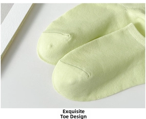 Detailed macro view of the smooth toe seam and fine knit texture on light green ankle socks