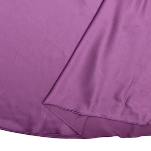 Macro shot of purple satin dress hemline showing neat stitching and smooth texture