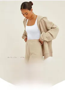 Close-up of white seamless ribbed yoga tank top with beige zip hoodie and drawstring shorts