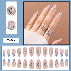 Faux ongles French bleus à fleurs, forme stiletto longue avec base nude et motifs floraux