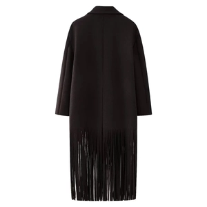 Detail view of the dense long fringe trim on the hem of this black woolen coat