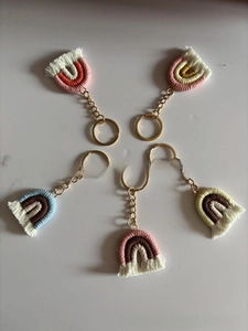 Detailed macro view of five colorful handmade knitted rainbow keychains with gold rings