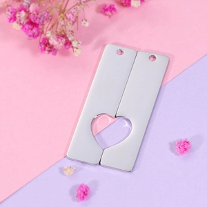 Detail of mirror polished stainless steel rectangle pendants with heart cutout for couples