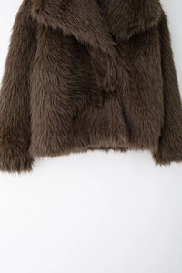 Close-up of thick faux fur texture and wide collar on dark brown plush jacket