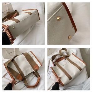 Detail view of canvas tote bag showing leather handles and metal bottom studs