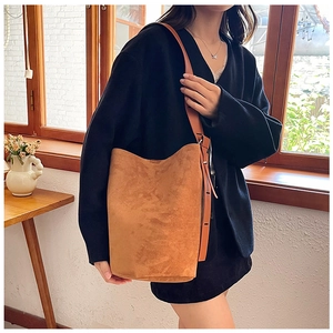 Detail of caramel brown suede tote bag with leather strap and silver buckle adjustment