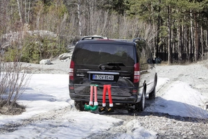Detail of Santa and elf leg ornaments hanging from a car trunk for Christmas decor
