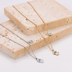 Hamsa hand and evil eye necklaces in gold and silver finish with crystal accents