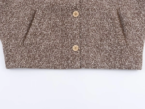 Detail of wool blend fabric with star embossed buttons and side pockets on brown jacket
