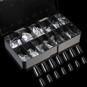 Macro detail of transparent stiletto nail tips in a labeled 10-grid black organizer box