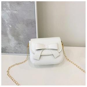 Close-up of white mini shoulder bag featuring a cute bow and gold chain strap detail