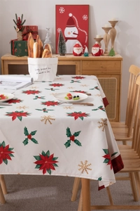Detailed view of Christmas tablecloth with poinsettia print and red plaid hem on wood table