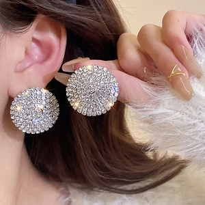 Sparkling silver-tone round earrings with full rhinestone inlay worn by a female model