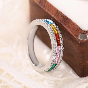 Macro shot of colorful rainbow baguette gemstones with milgrain edging on a silver ring