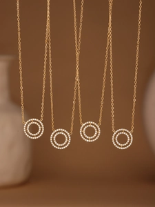 Close-up of gold double-circle necklaces with shimmering pavé zircon and 18k gold plating