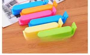 Set of 6 colorful plastic food sealing clips for kitchen bag closure on wood surface