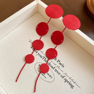 Detail of red long fringe earrings with circular textured sequins and s925 silver needles