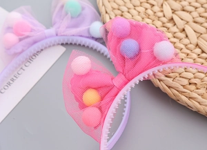 Detail of girls mesh bow headbands with colorful plush balls and non-slip teeth