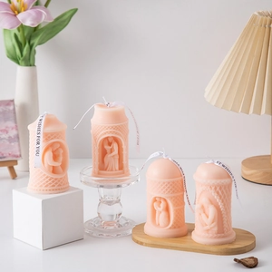 Artistic pink pillar candle with romantic couple relief carvings and silk ribbon detail