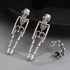 Gothic silver skeleton earrings and skull ear cuff set displayed on a dark tray
