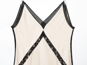 Detailaufnahme des champagnerfarbenen Satin-Slipkleids mit schwarzer Spitze und Mesh-Ausschnitt