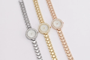 Drei elegante Uhren mit Kristalllünette in Silber, Gold und Roségold auf weißem Hintergrund