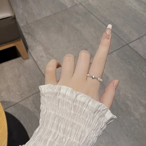 Baroque pearl stretch ring with heart charm and silver beads shown on model hand