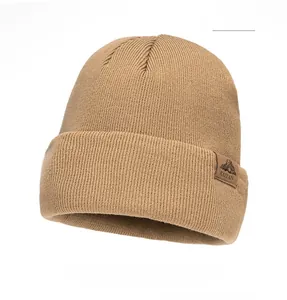 Close-up of khaki ribbed knit beanie showing mountain logo patch and fabric texture