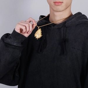 Close-up of gold-plated Indian head pendant necklace worn by a male model