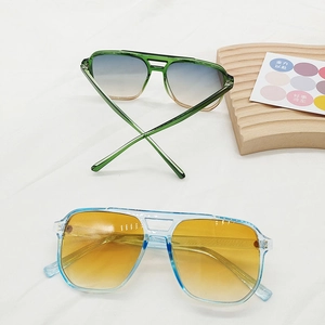 Detail of square vintage sunglasses with gradient lenses and transparent colorful frames
