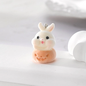 Macro shot of flocked white rabbit pendant with an orange pumpkin base and metal ring