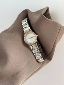 Detailed macro view of crystal bezel and white dial on a two-tone luxury watch